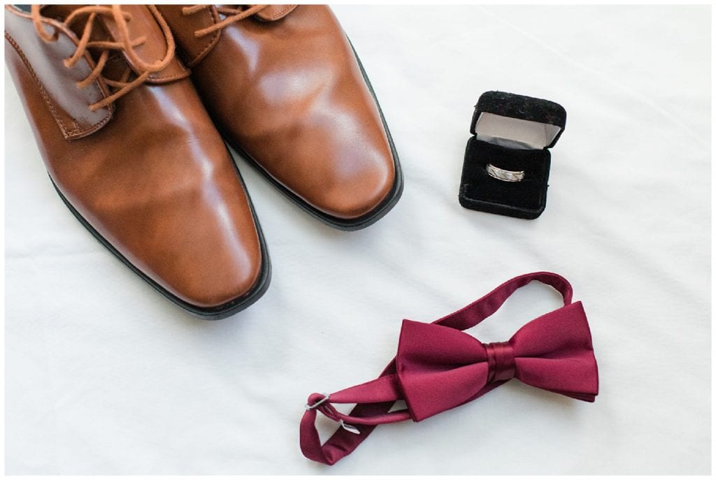 Groom's getting ready details, dress shoes, guy's ring box, and red bow tie.