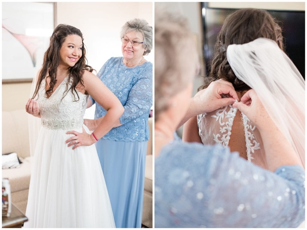 Mother helping bride into her dress on her wedding day.