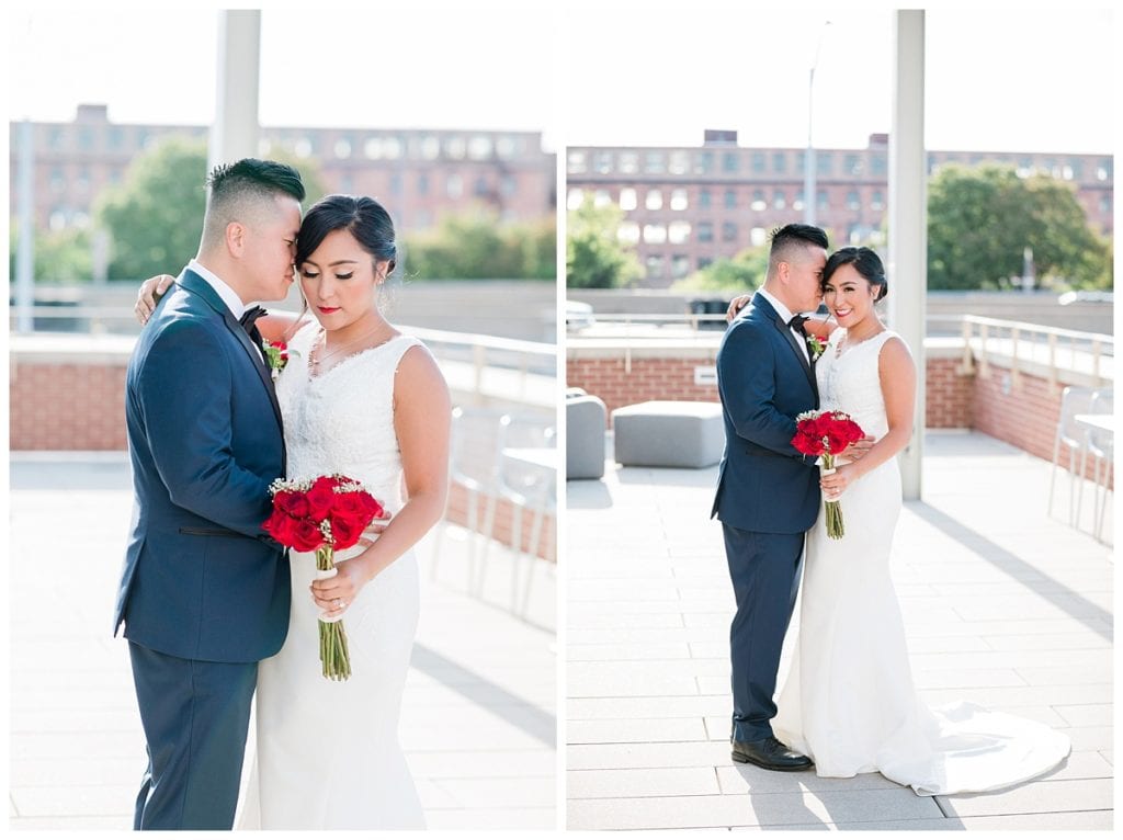 Groom in blue tux and bride in white wedding dress with red flowers posing in wedding pictures at Downtown Market wedding.