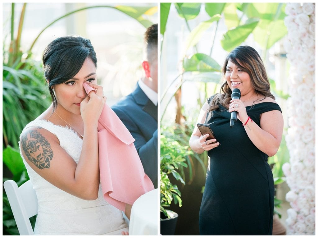 Bride crying during speech by bridesmaid in black dress at Downtown Market.