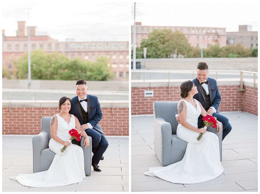 Bride and groom sitting on grey chair on rooftop of Downtown Market Grand Rapids for wedding pictures.
