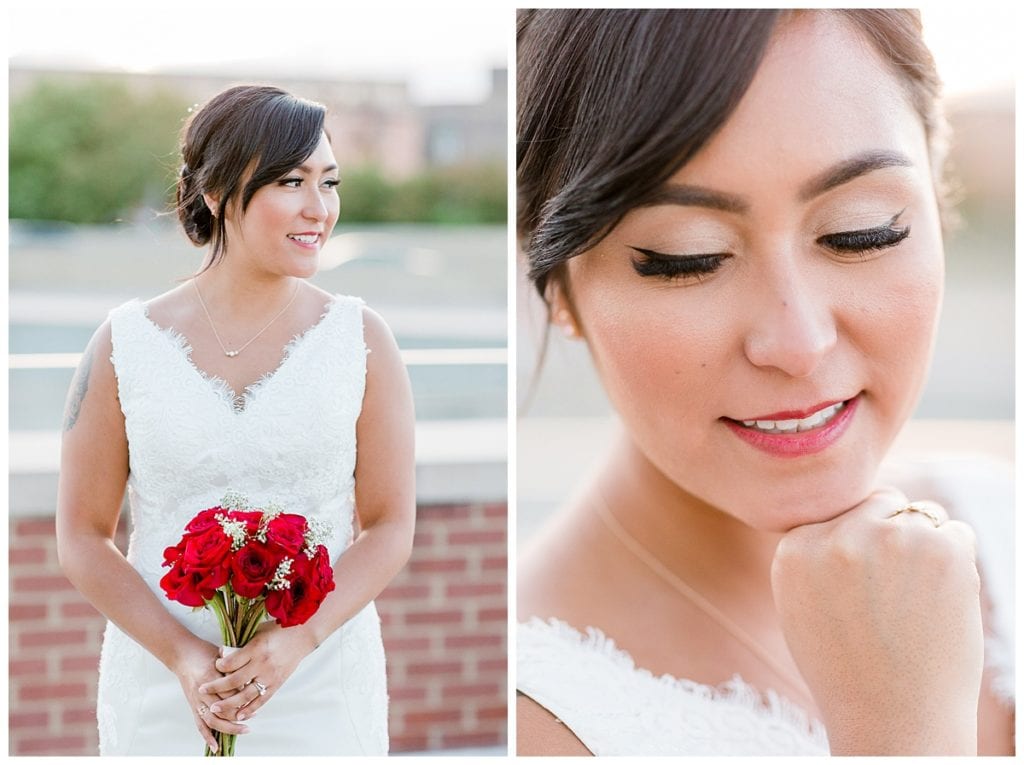 Bride holding red bouquet and resting her hand on her chin on wedding day at Downtown Market Grand Rapids.